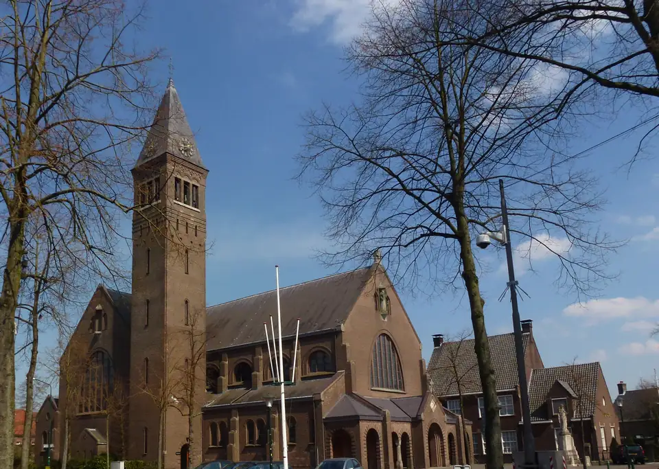 De Sint-Willibrorduskerk in Waalre achter de bomen